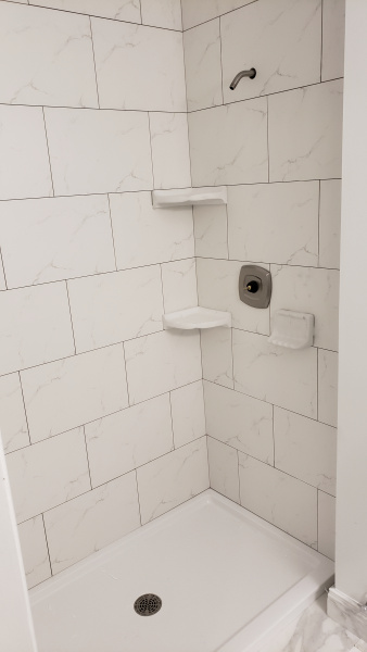 Fiberglass shower base and porcelain tile around